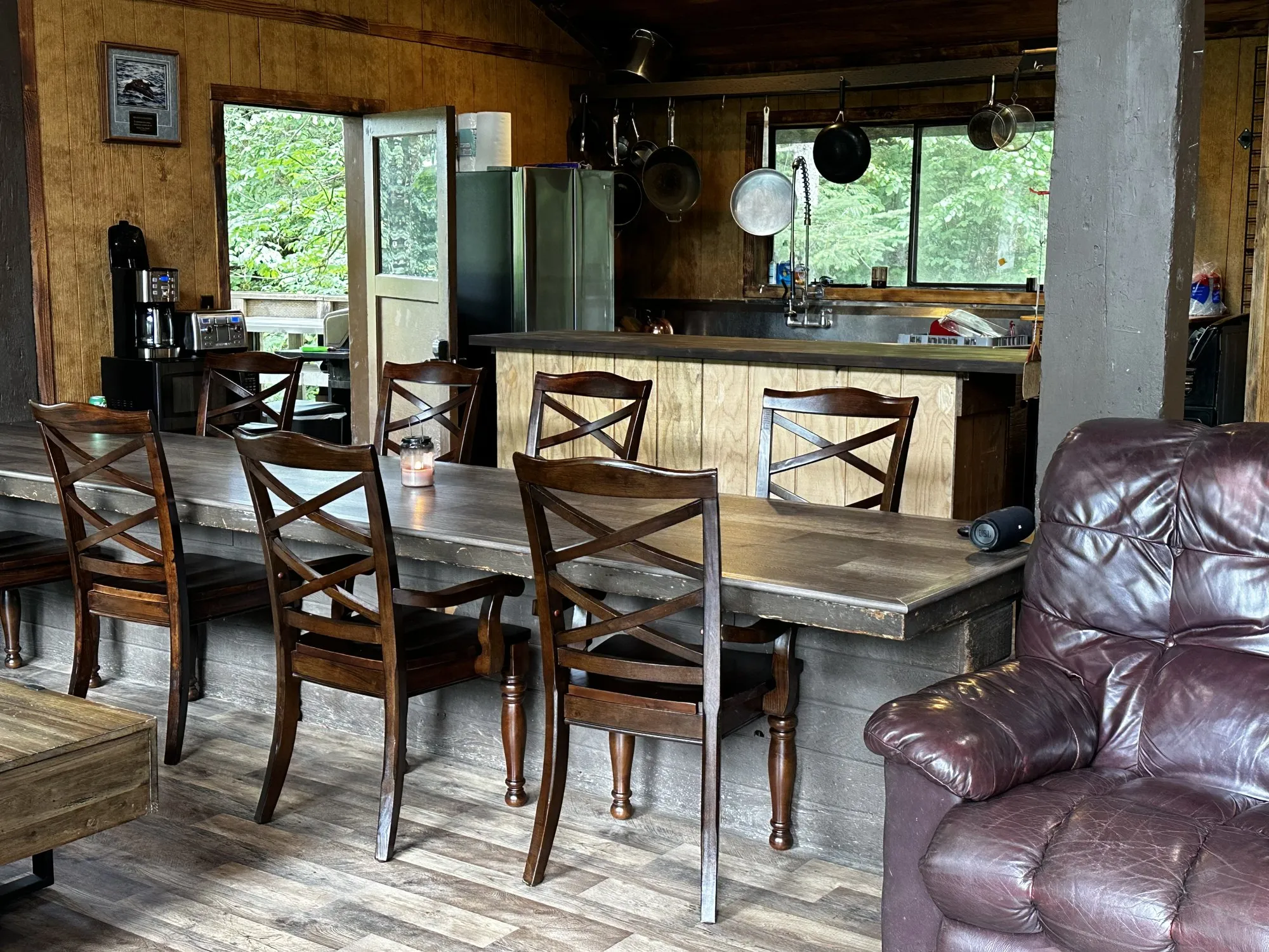 The lodge kitchen and dining area, with a long farm table and a wood-clad island