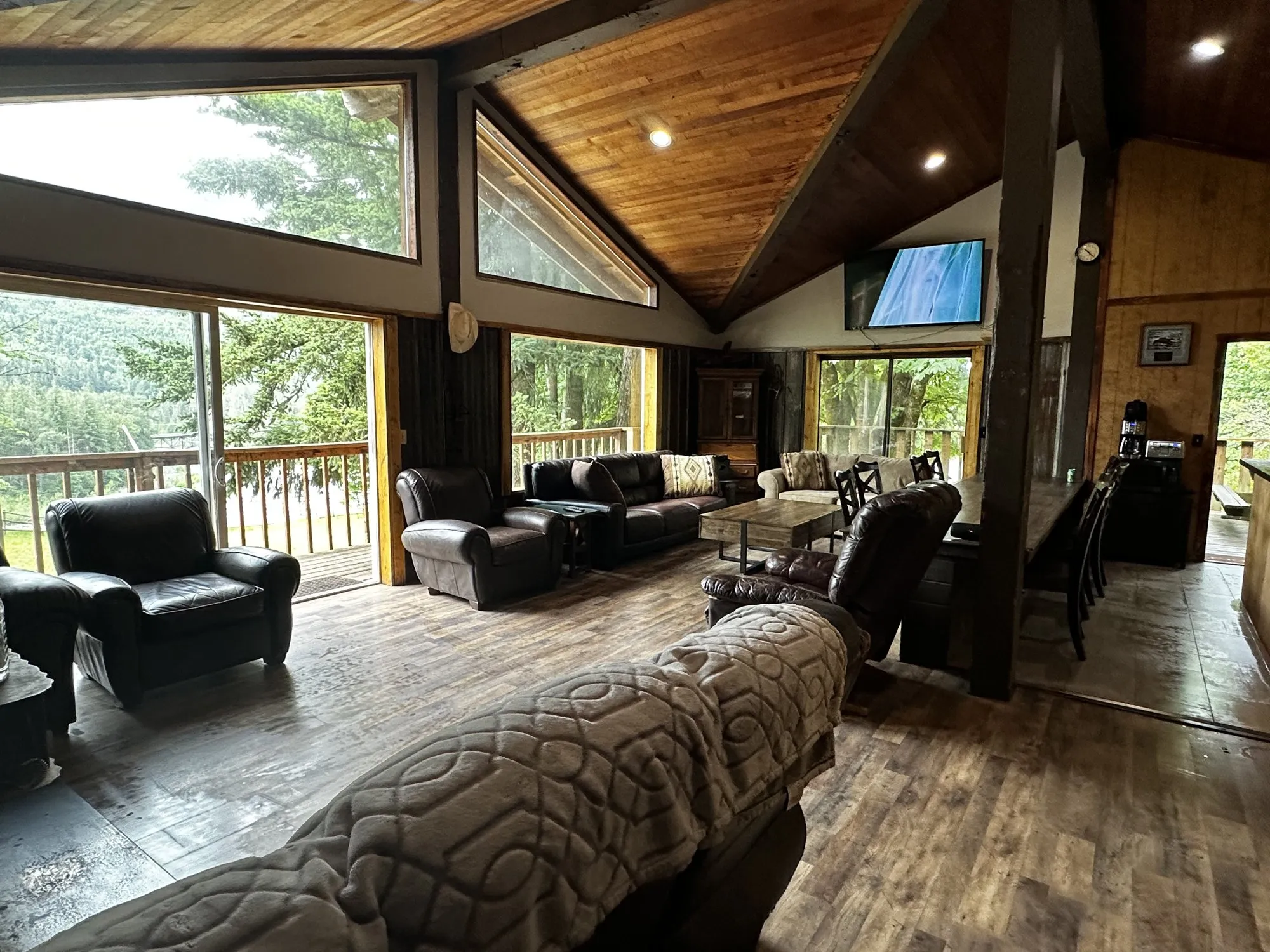 The main lodge living room at Skyland Ranch, with vaulted cedar ceilings and a wall of windows overlooking the forest
